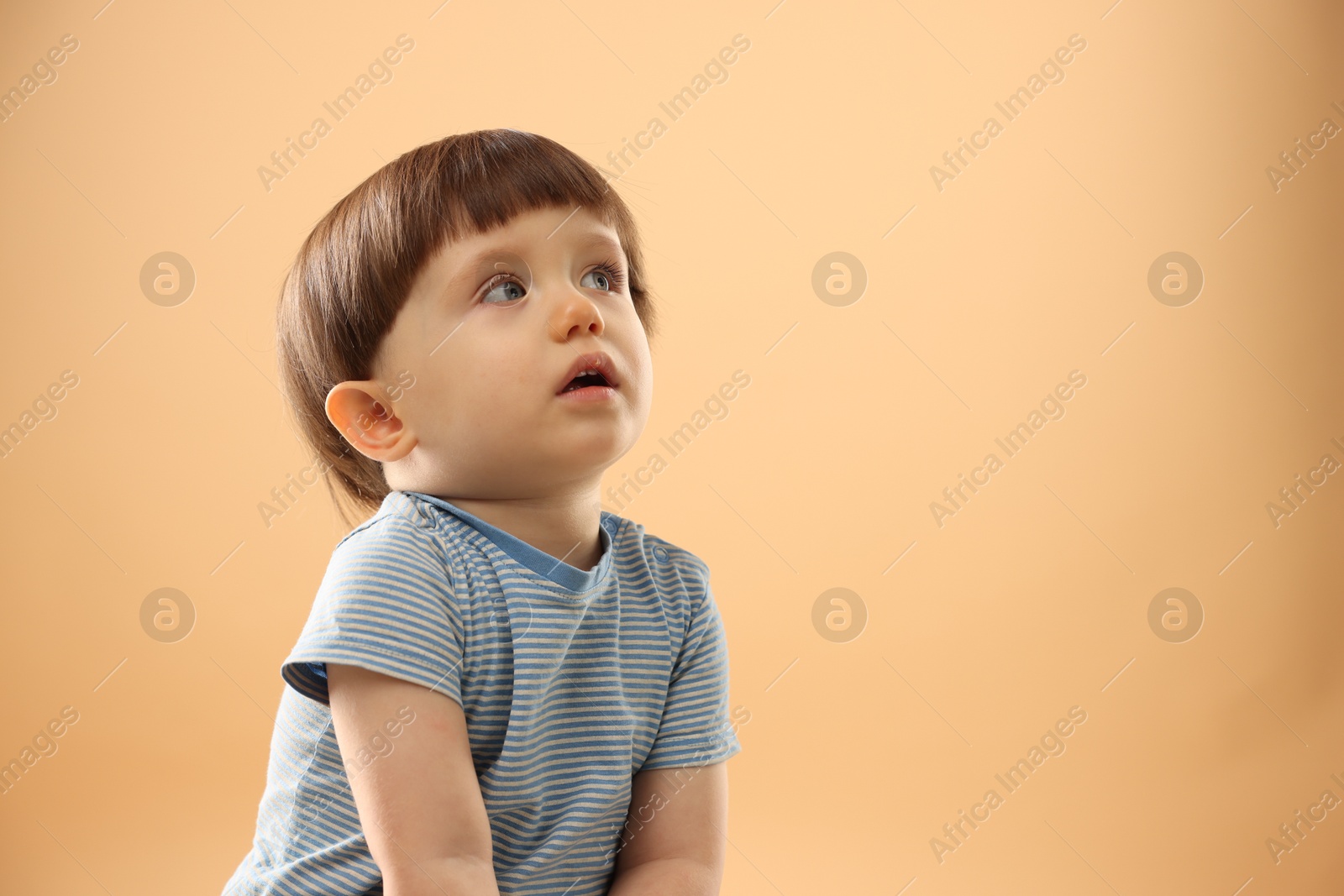 Photo of Portrait of cute little boy on beige background. Space for text