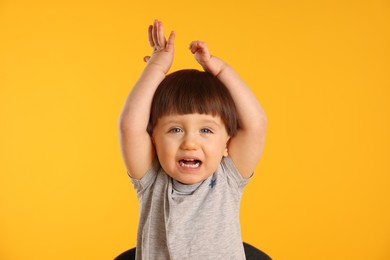 Photo of Portrait of emotional little boy on yellow background