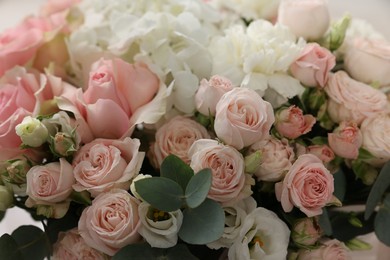 Photo of Bouquet of beautiful flowers and eucalyptus branches, closeup