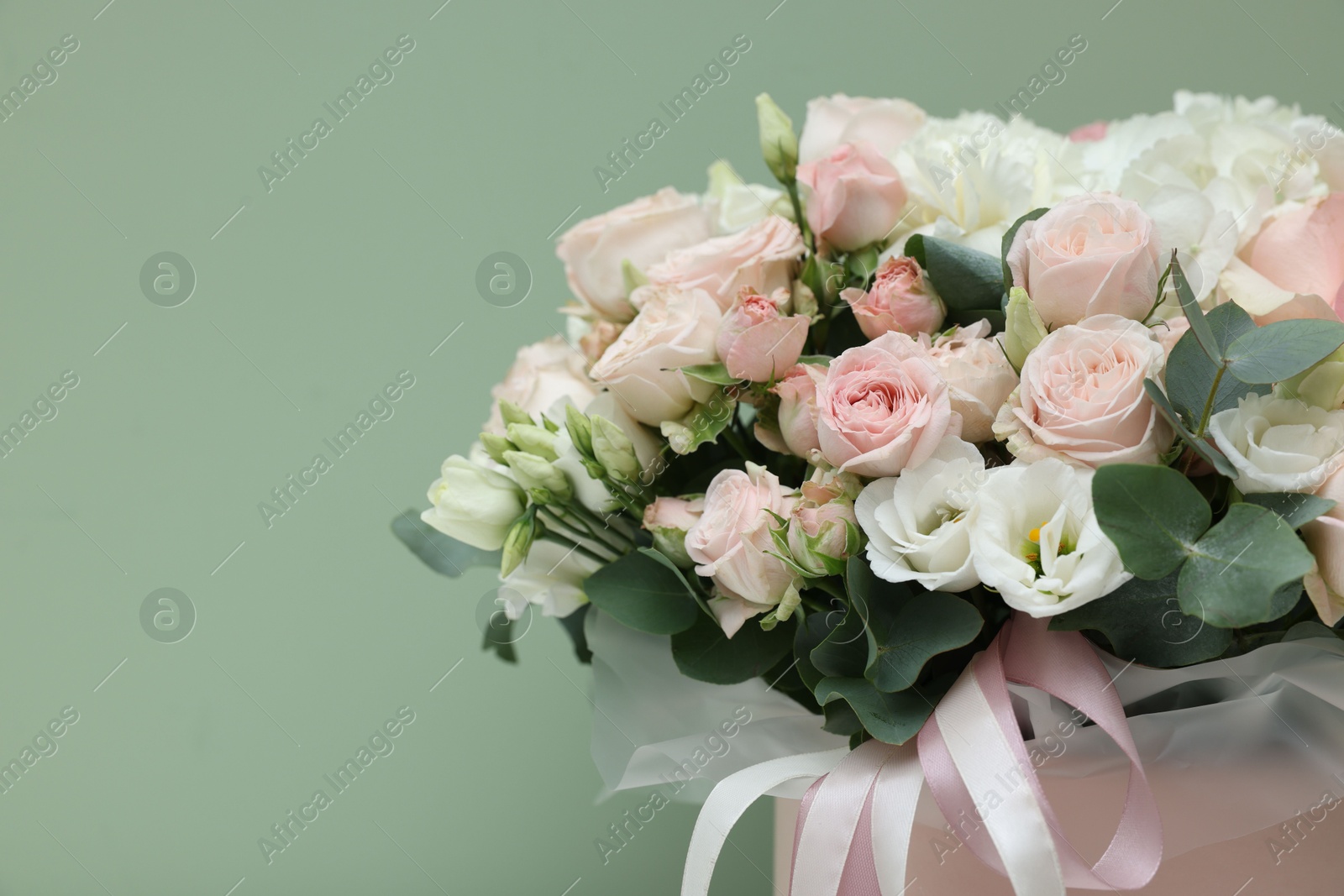 Photo of Bouquet of beautiful flowers and eucalyptus branches on green background, closeup. Space for text