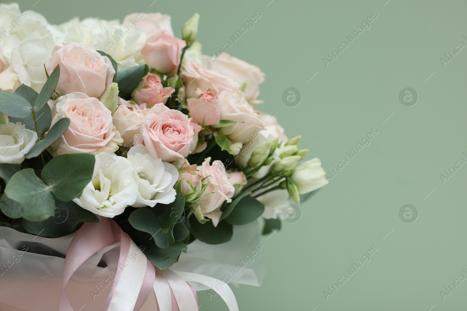 Photo of Bouquet of beautiful flowers and eucalyptus branches on green background, closeup. Space for text