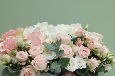 Photo of Bouquet of beautiful flowers and eucalyptus branches on green background, closeup