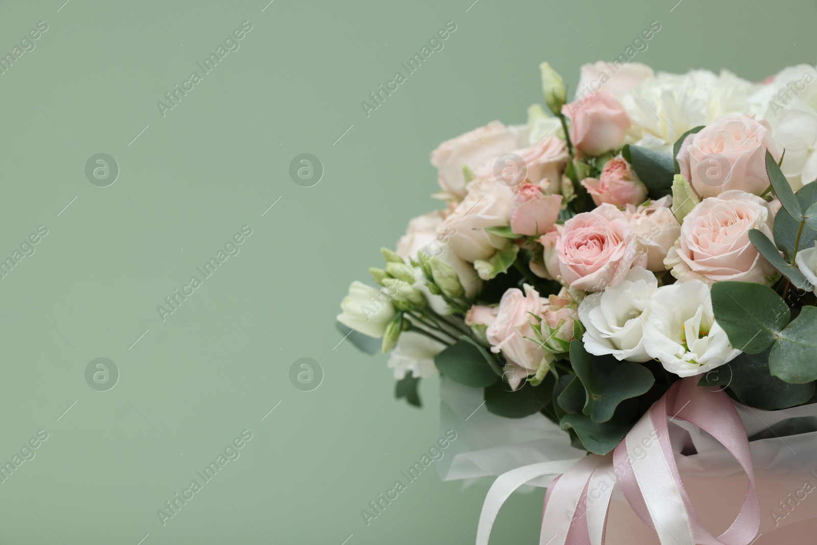 Photo of Bouquet of beautiful flowers and eucalyptus branches on green background, closeup. Space for text