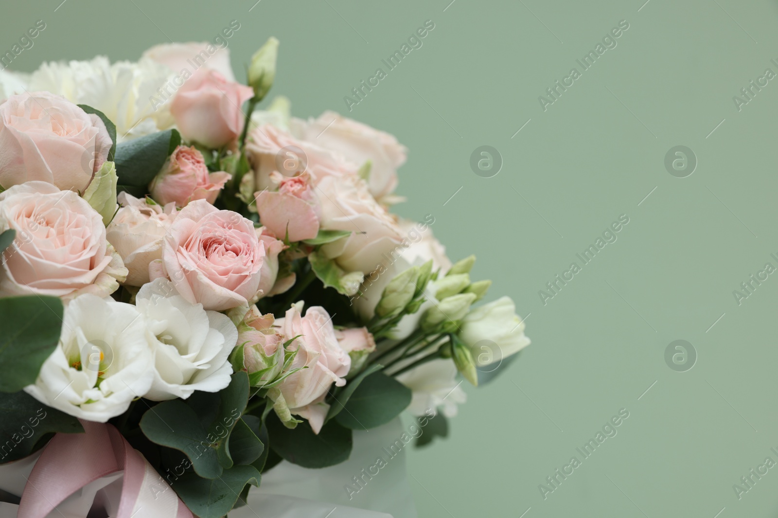 Photo of Bouquet of beautiful flowers and eucalyptus branches on green background, closeup. Space for text