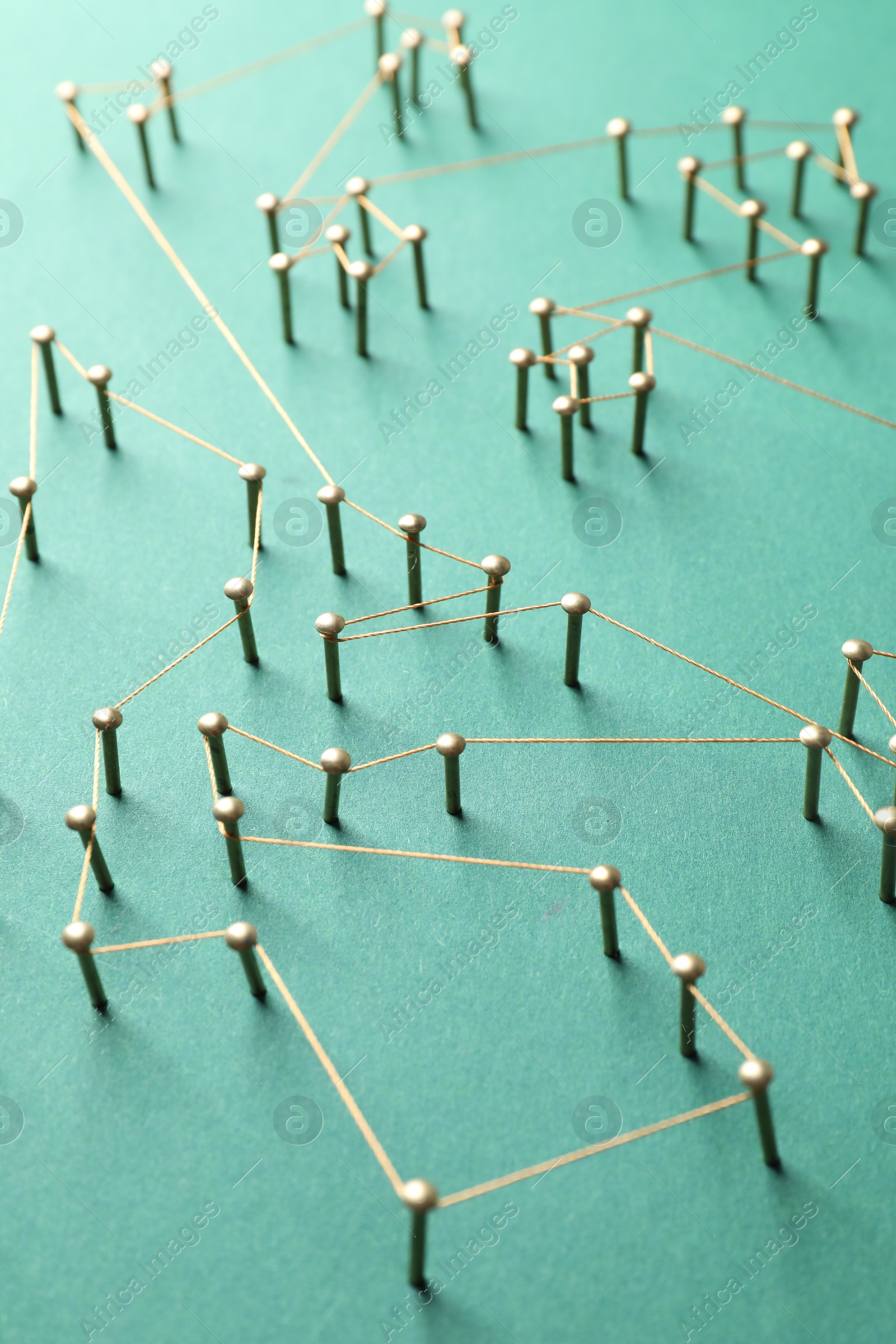 Photo of Network connection. Nails linked together by thread on green background, closeup