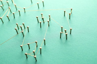 Photo of Network connection. Nails linked together by thread on green background, closeup