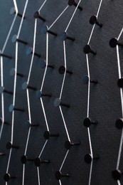 Photo of Network connection. Nails linked together by thread on black background, closeup