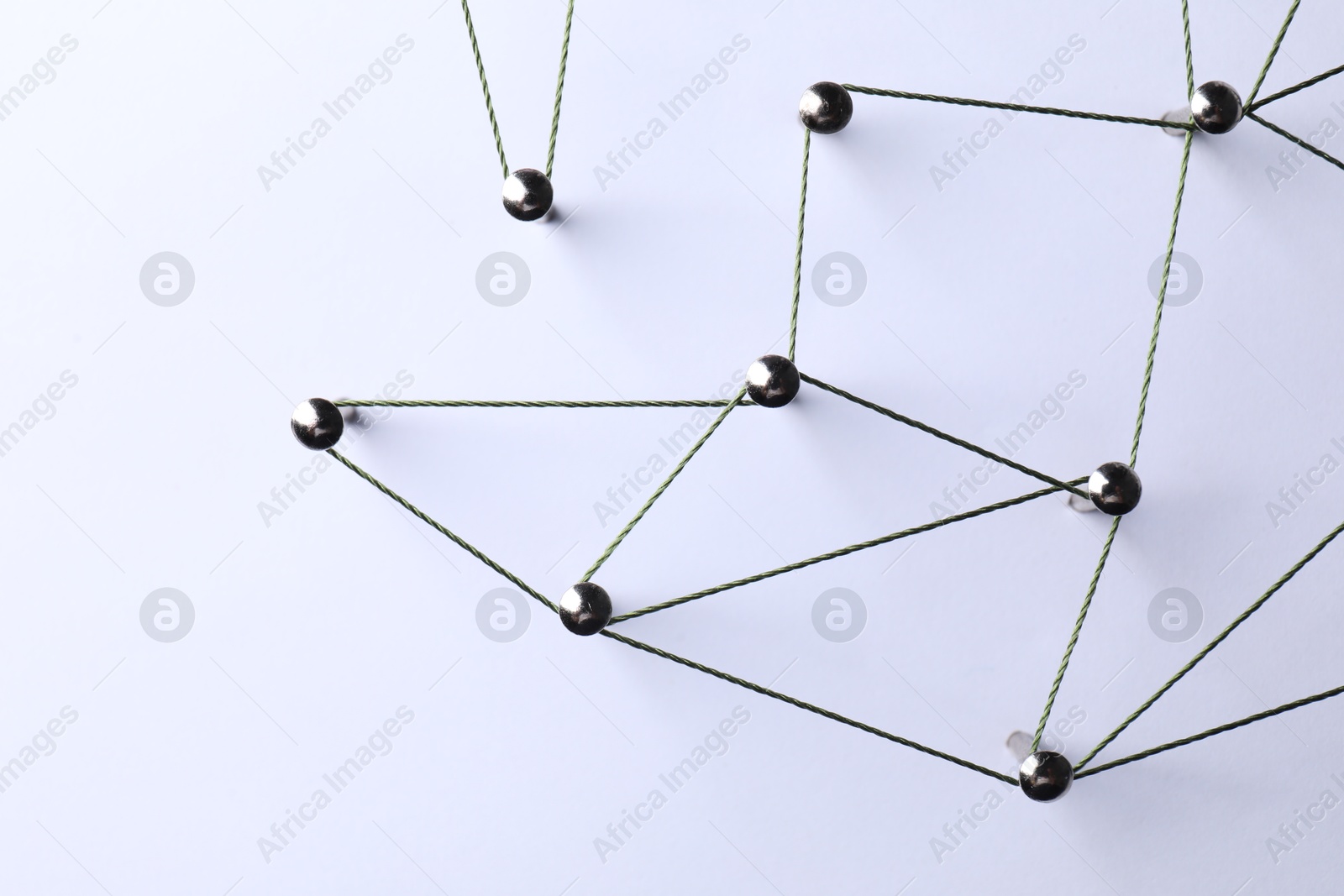 Photo of Network connection. Nails linked together by threads on white background, flat lay