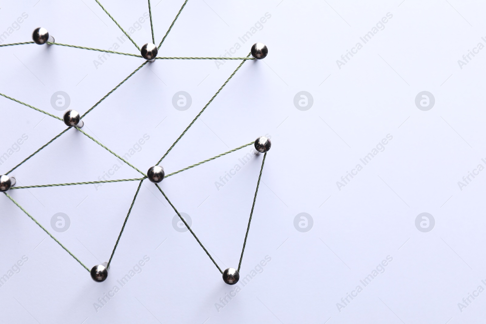 Photo of Network connection. Nails linked together by threads on white background, flat lay. Space for text