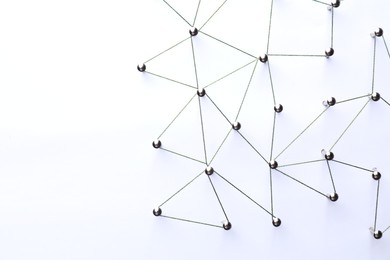 Photo of Network connection. Nails linked together by threads on white background, flat lay. Space for text