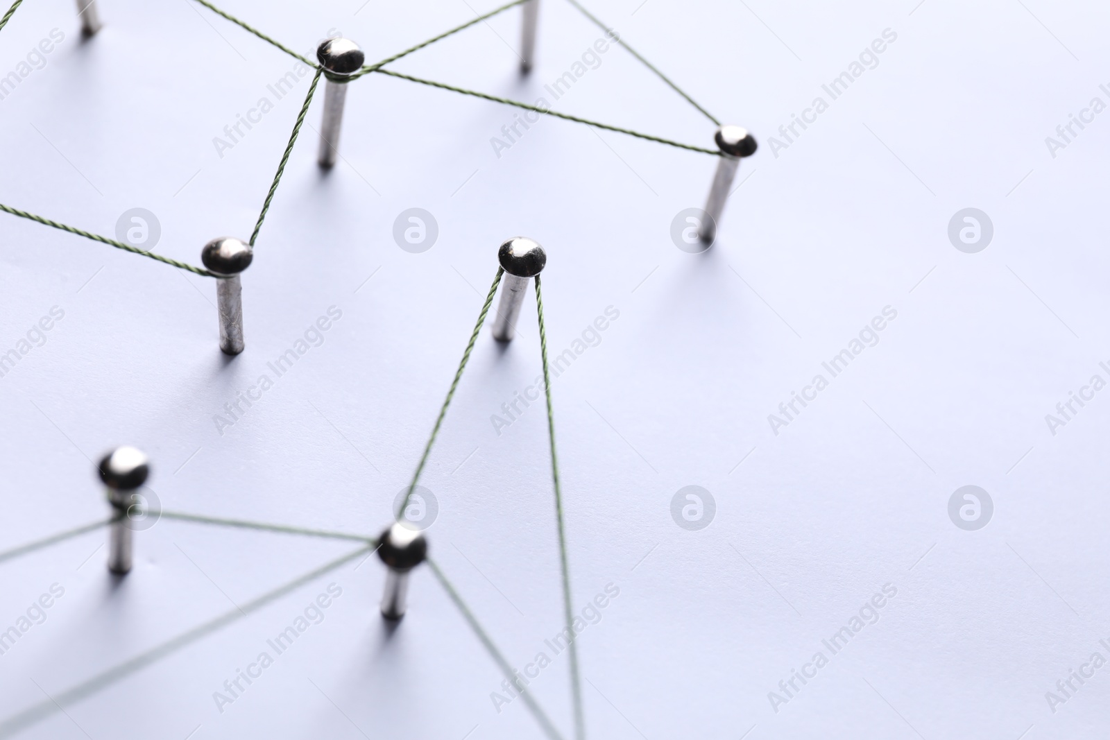 Photo of Network connection. Nails linked together by threads on white background, closeup. Space for text