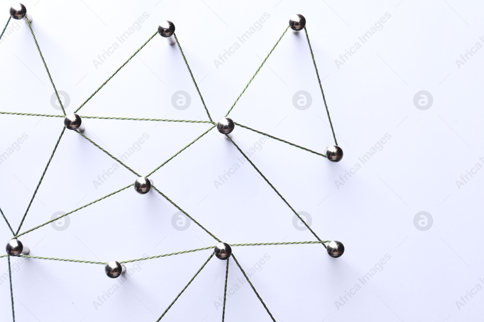 Photo of Network connection. Nails linked together by threads on white background, flat lay. Space for text