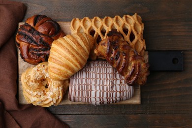 Photo of Different sweet pastries on wooden table, top view