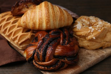 Photo of Different sweet pastries on wooden table, closeup