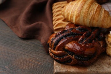 Photo of Different sweet pastries on wooden table, closeup. Space for text