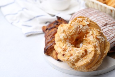 Photo of Different sweet pastries on light table, closeup. Space for text