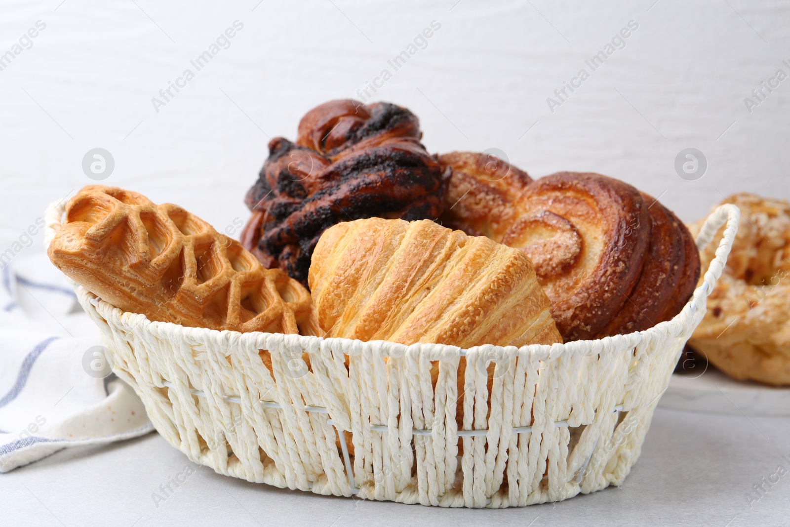 Photo of Different pastries in basket on light table