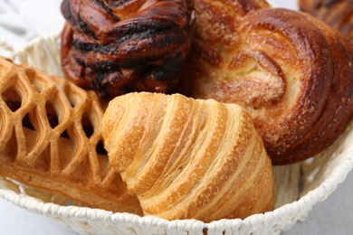 Different pastries in basket on light table, closeup