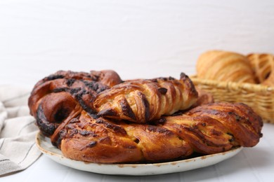 Photo of Different sweet pastries on white tiled table, closeup