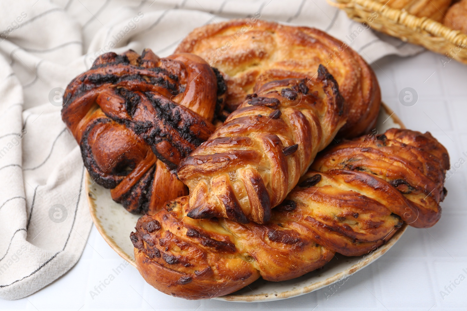 Photo of Different sweet pastries on white tiled table, closeup