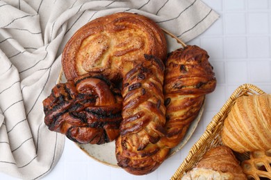 Photo of Different sweet pastries on white tiled table, flat lay