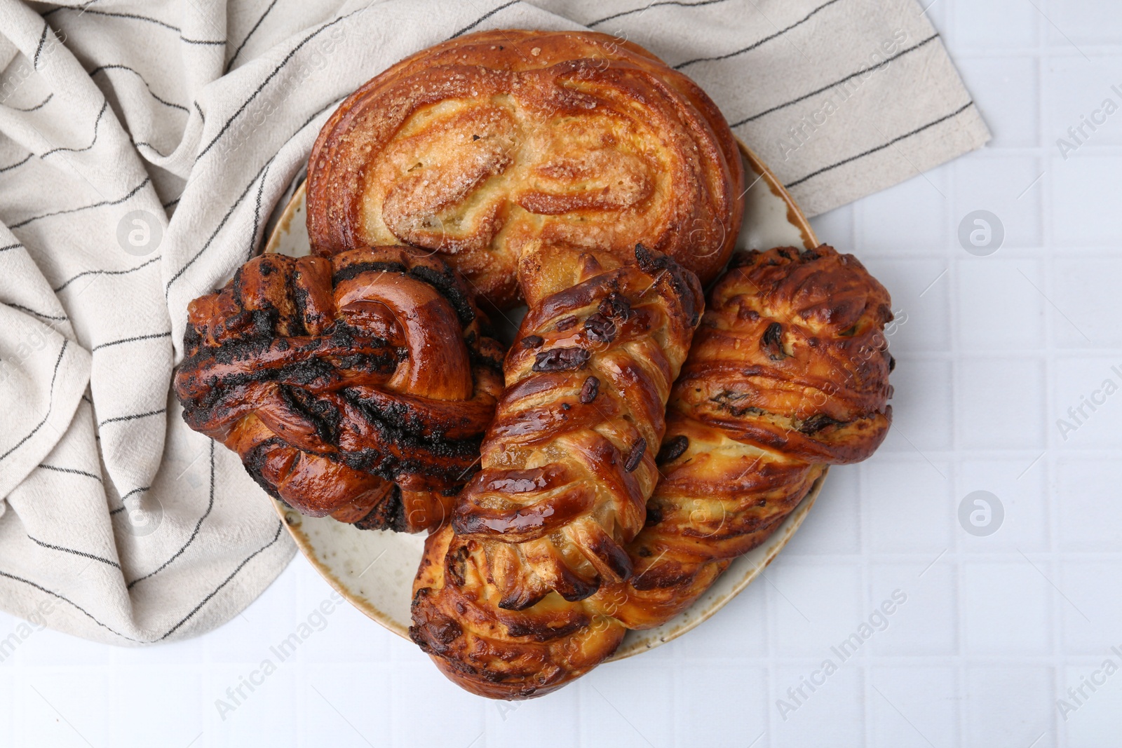 Photo of Different sweet pastries on white tiled table, top view