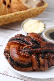 Photo of Delicious poppy seed pastry, butter and coffee on white wooden table, closeup