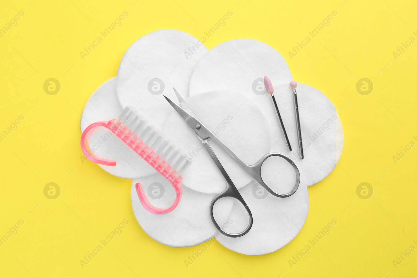 Photo of Set of pedicure tools on yellow background, flat lay