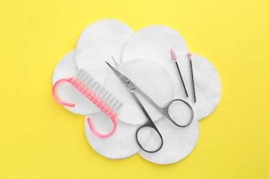 Photo of Set of pedicure tools on yellow background, flat lay