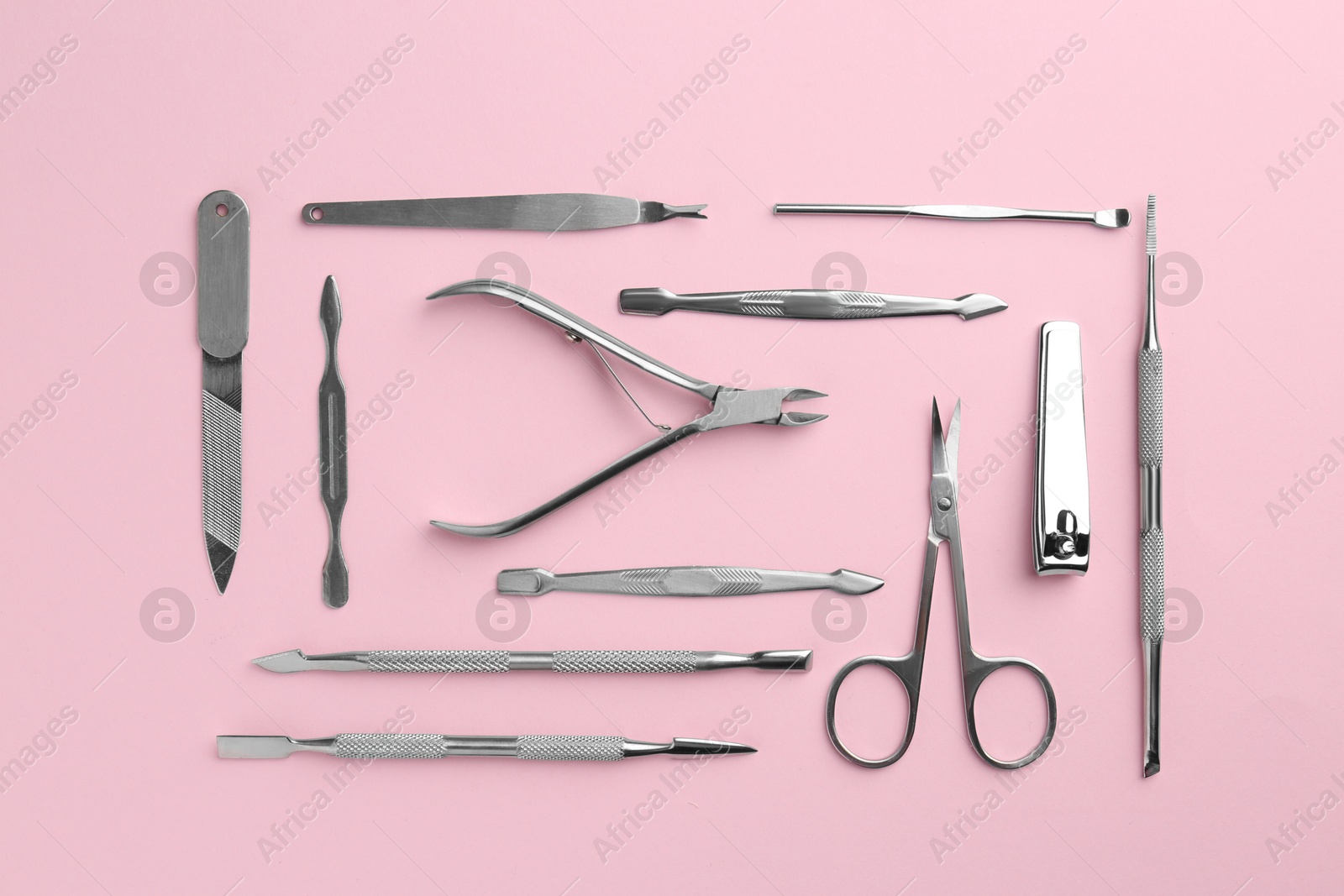 Photo of Set of pedicure tools on pink background, flat lay