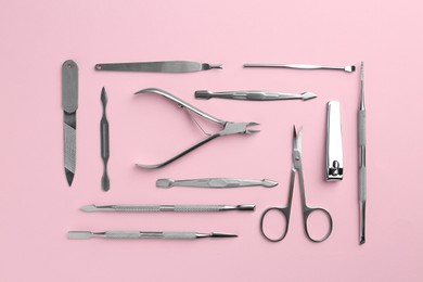 Photo of Set of pedicure tools on pink background, flat lay