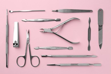 Photo of Set of pedicure tools on pink background, flat lay