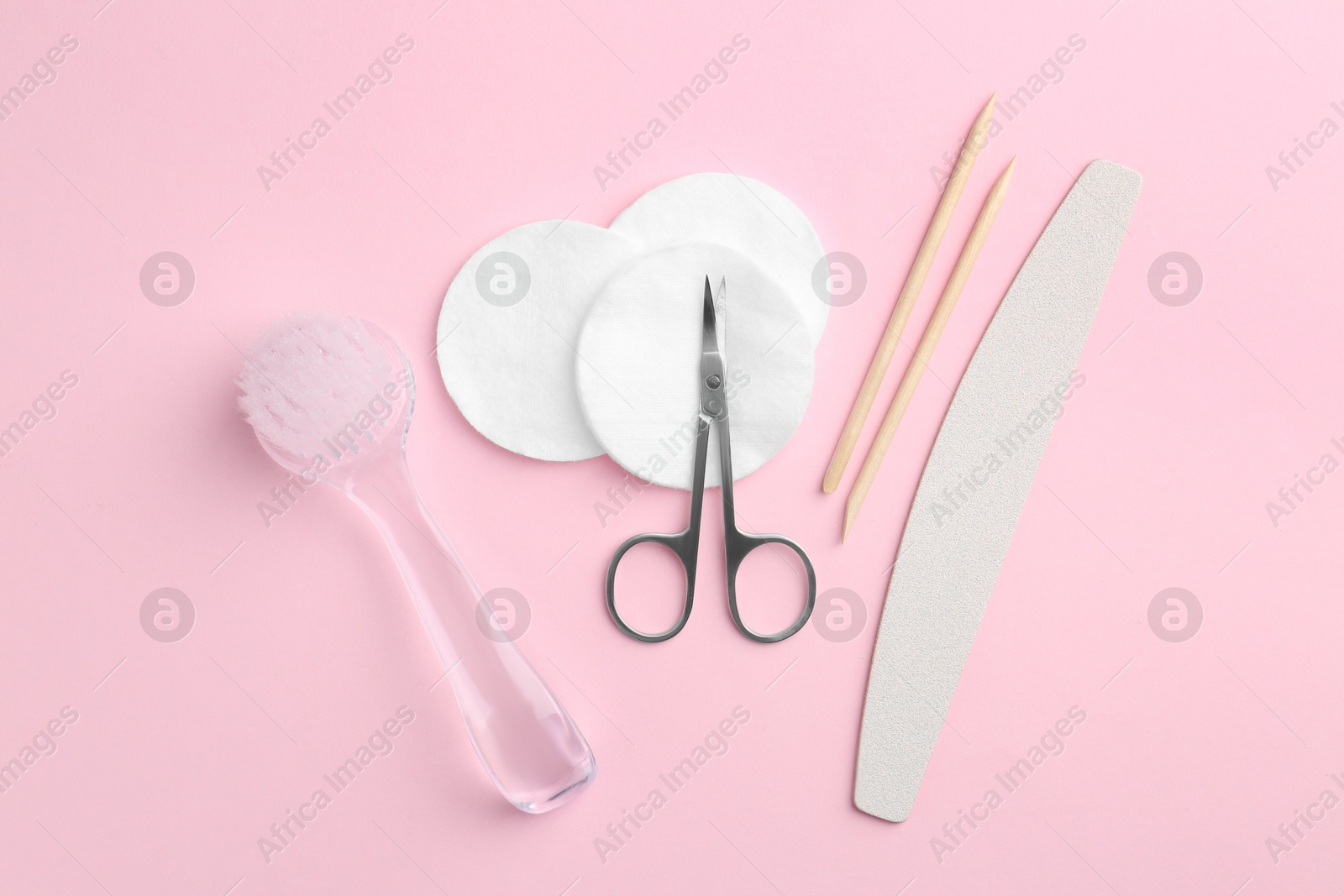 Photo of Set of pedicure tools on pink background, flat lay