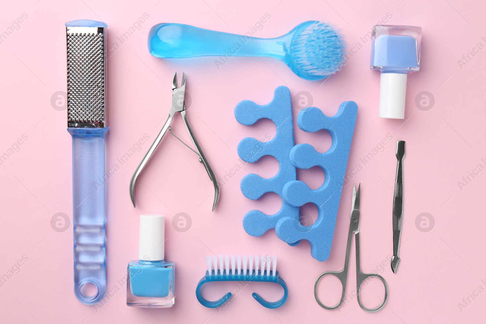 Photo of Set of pedicure tools on pink background, flat lay