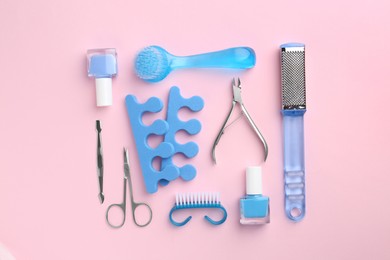 Photo of Set of pedicure tools on pink background, flat lay