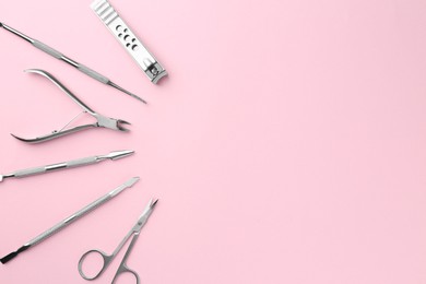 Photo of Set of pedicure tools on pink background, flat lay. Space for text