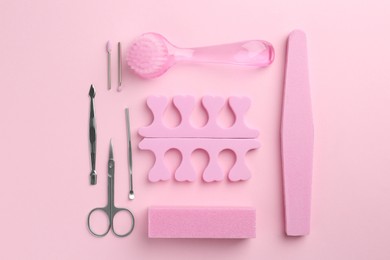 Photo of Set of pedicure tools on pink background, flat lay