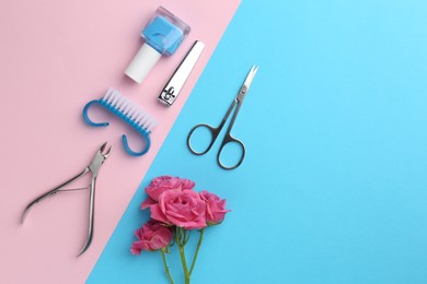 Photo of Set of pedicure tools and flowers on color background, flat lay. Space for text