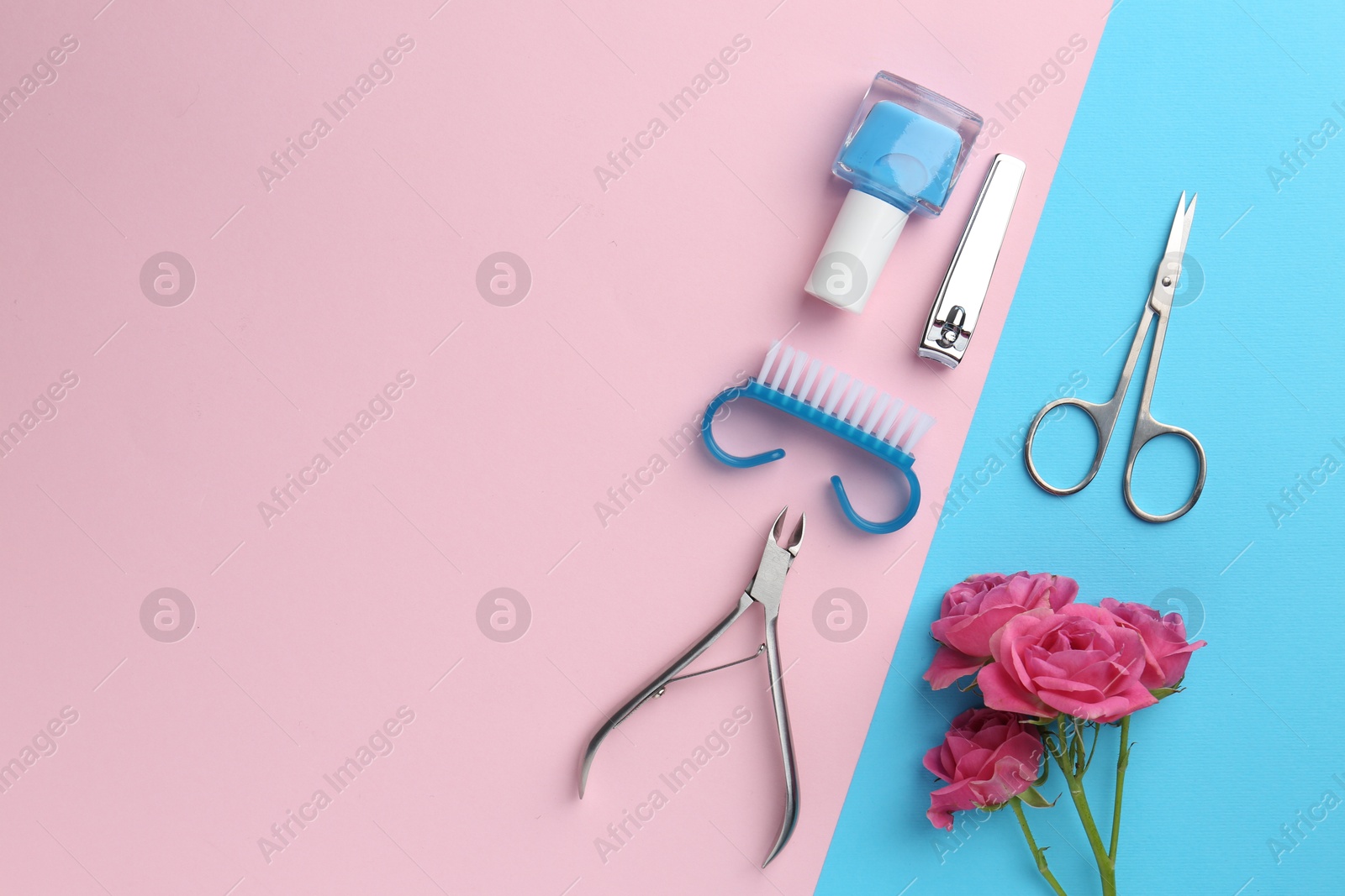 Photo of Set of pedicure tools and flowers on color background, flat lay. Space for text