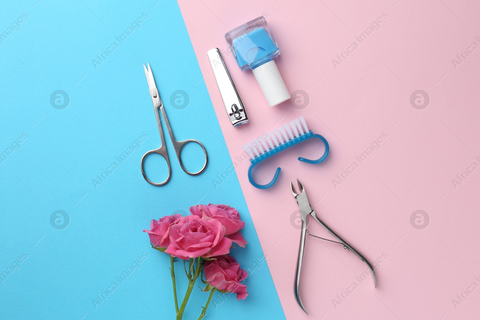 Photo of Set of pedicure tools and flowers on color background, flat lay