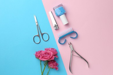 Photo of Set of pedicure tools and flowers on color background, flat lay