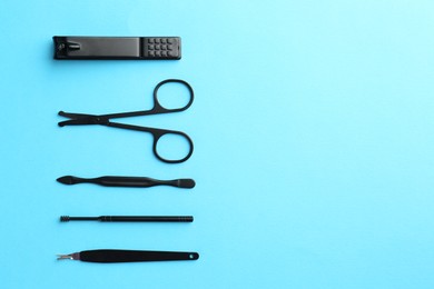 Photo of Set of pedicure tools on light blue background, flat lay. Space for text