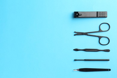 Photo of Set of pedicure tools on light blue background, flat lay. Space for text