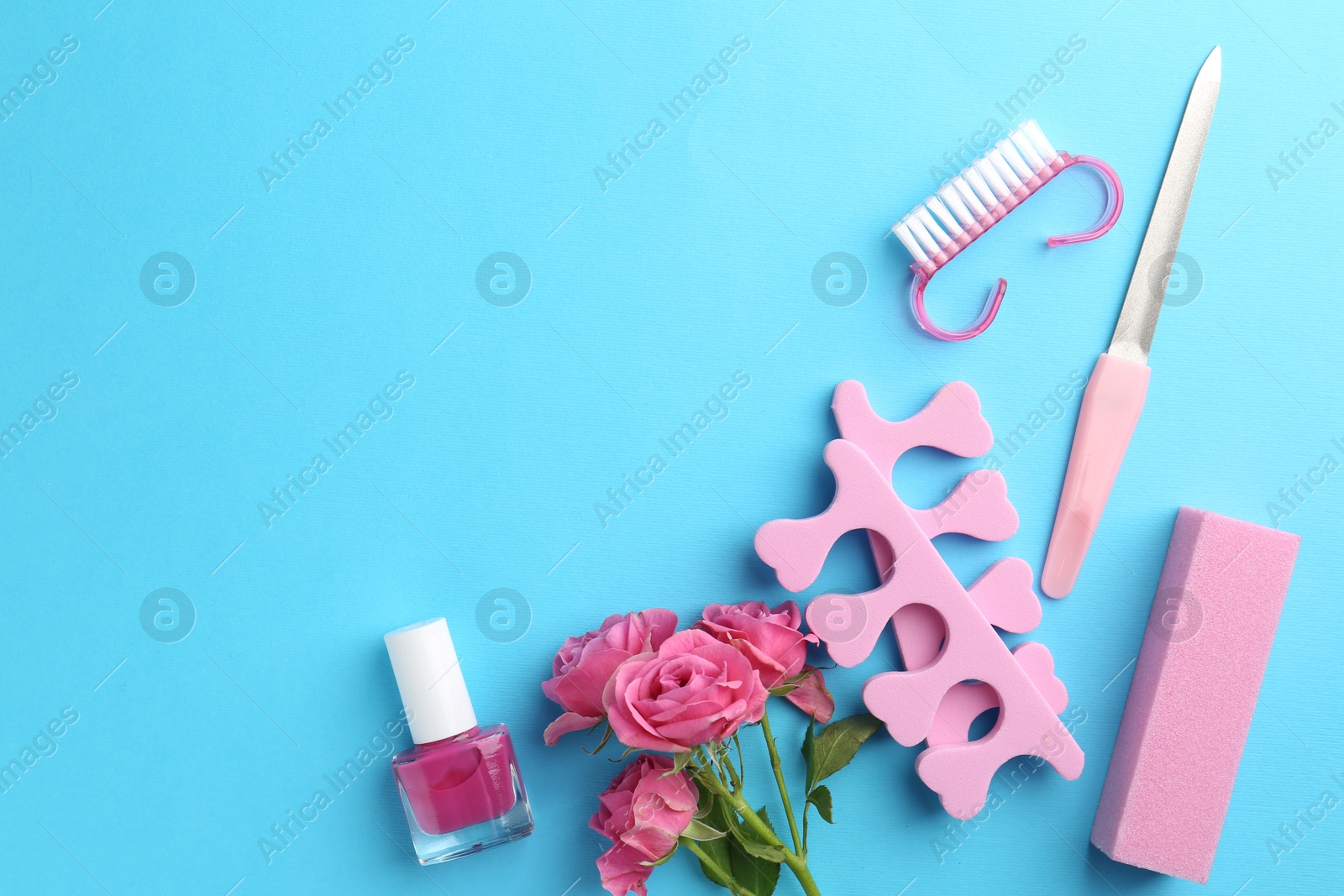 Photo of Set of pedicure tools on light blue background, flat lay. Space for text