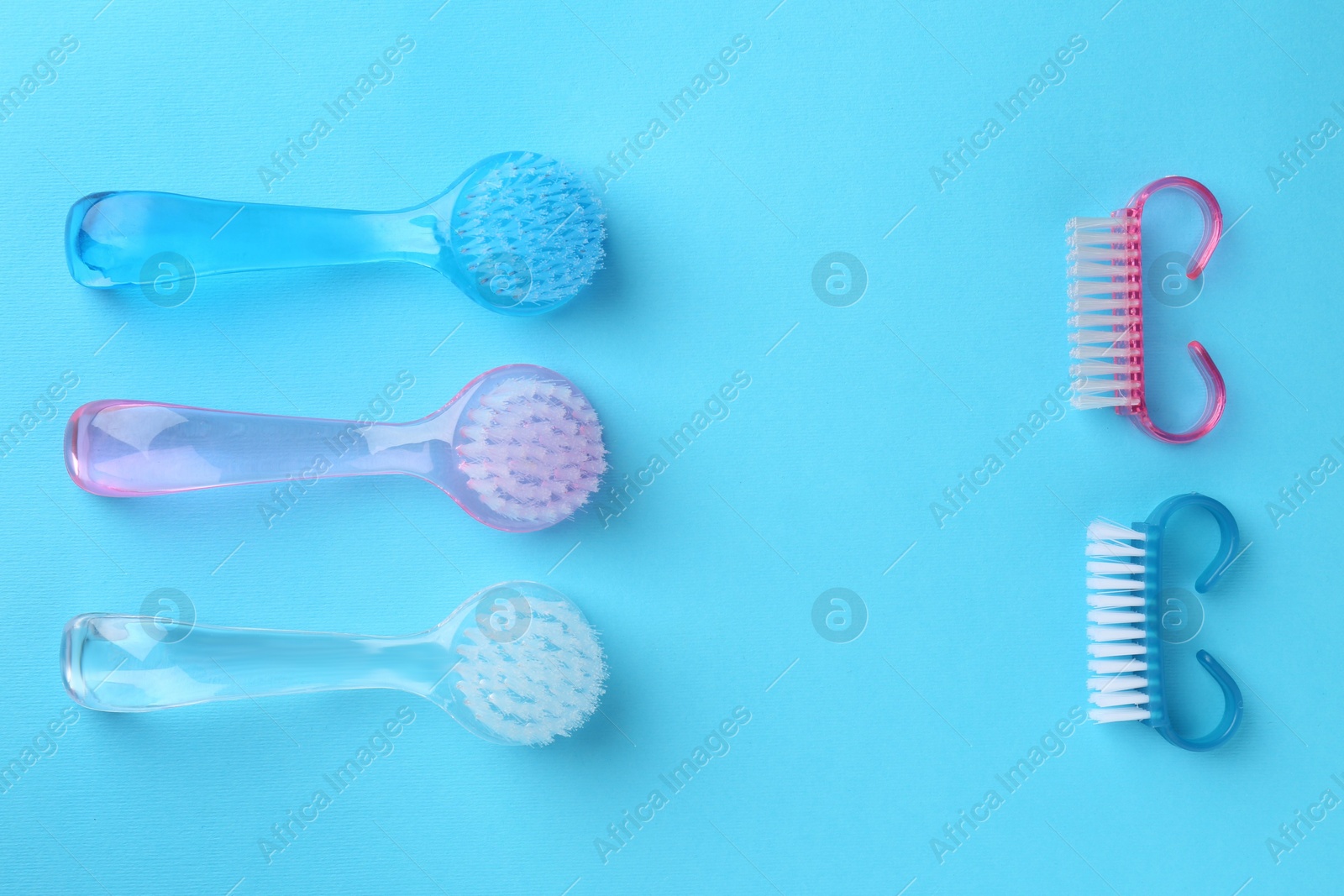 Photo of Pedicure procedure. Different brushes on light blue background, flat lay. Space for text