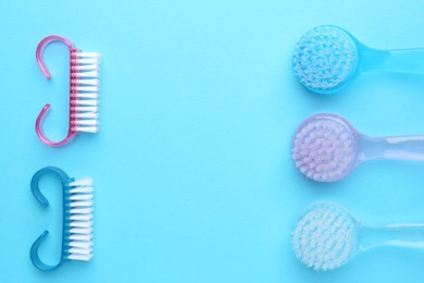 Photo of Pedicure procedure. Different brushes on light blue background, flat lay. Space for text