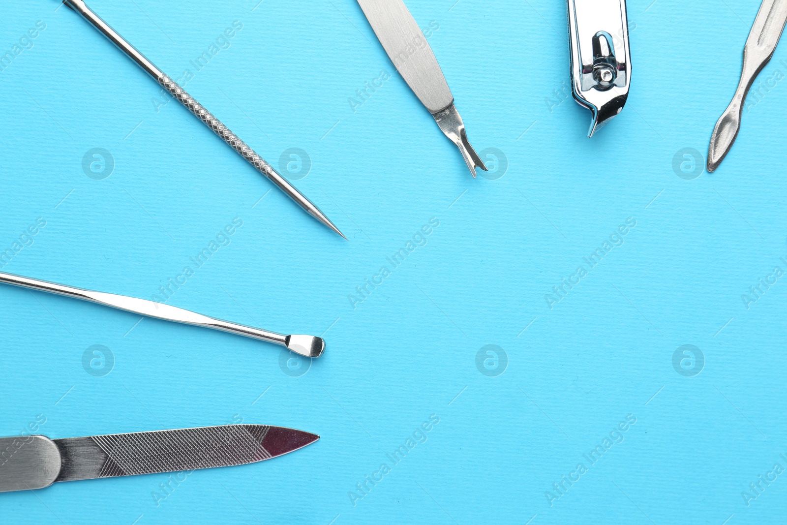 Photo of Set of pedicure tools on light blue background, flat lay. Space for text