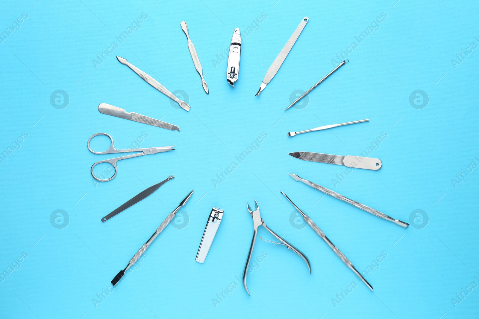 Photo of Set of pedicure tools on light blue background, flat lay