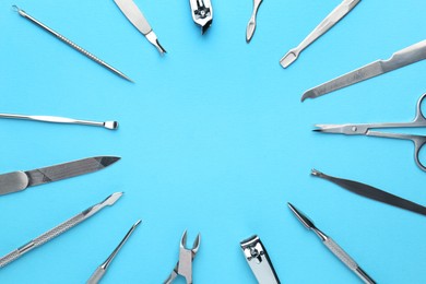 Photo of Set of pedicure tools on light blue background, flat lay. Space for text