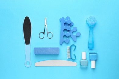 Photo of Set of pedicure tools on light blue background, flat lay